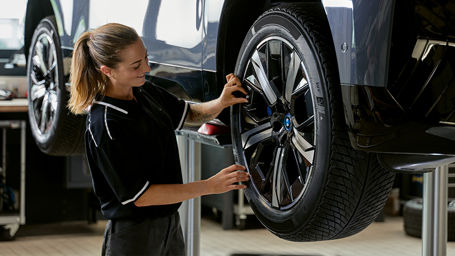 Servicespezialistin prüft Reifen BMW Feriencheck Servicespezialistin prüft Reifen