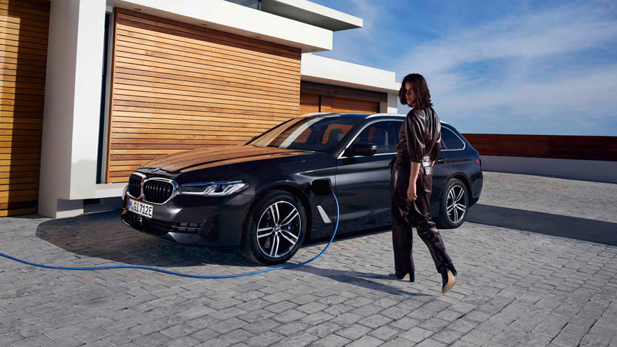 Femme/BMW/Série 3 Touring/noir/latéral/borne de recharge/maison