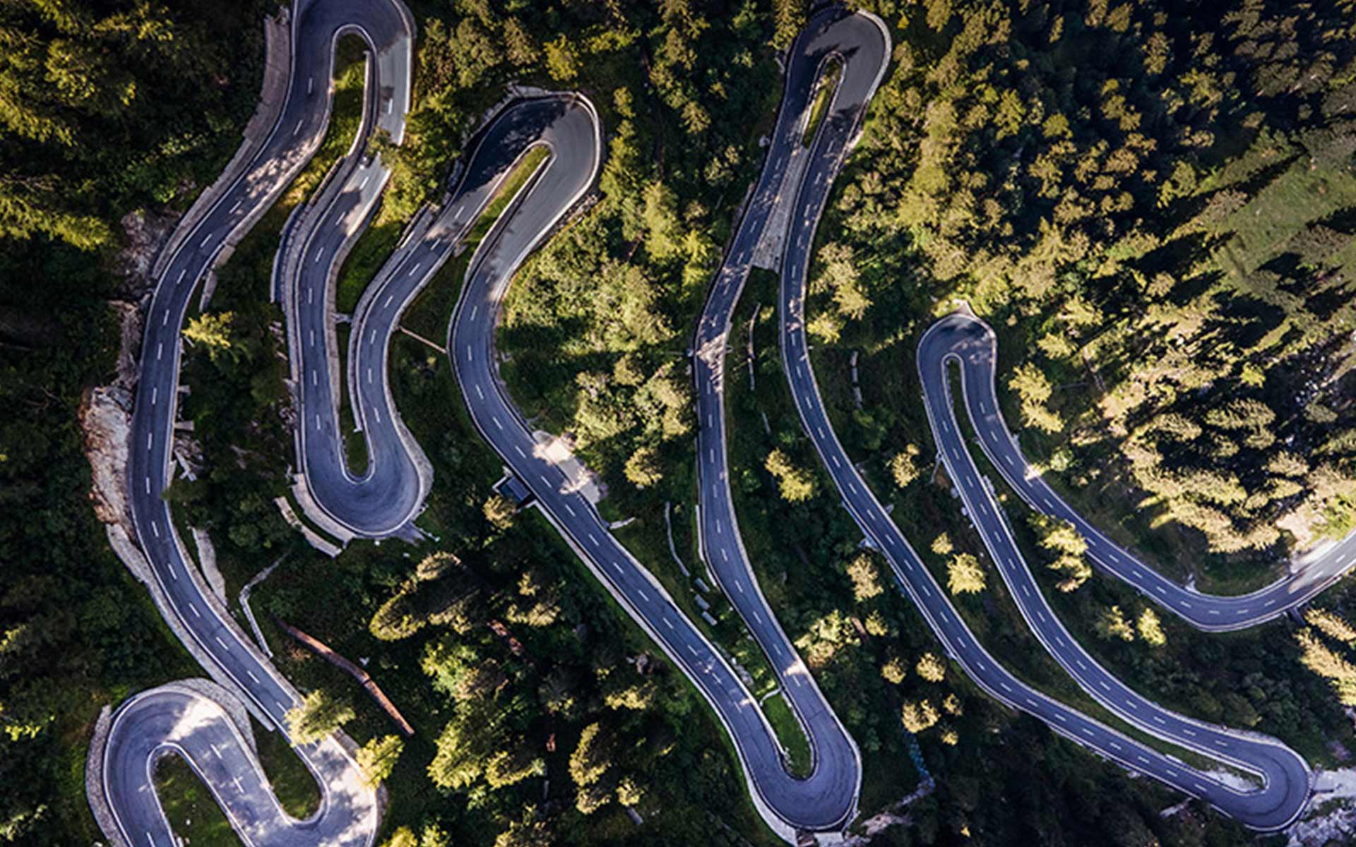 Vue en plongée route qui serpente dans un paysage boisé