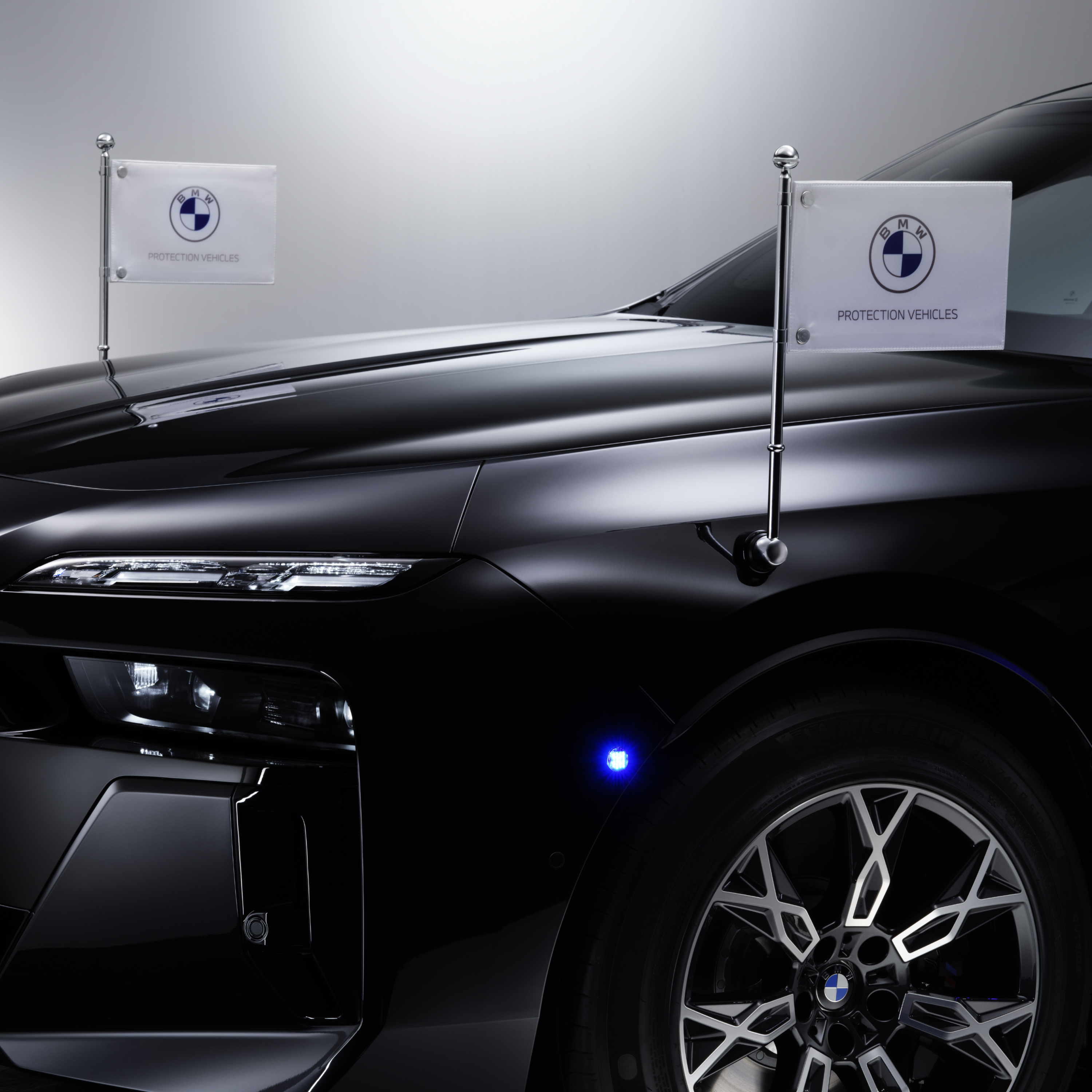 Vista dettagliata di una BMW con due portabandierine